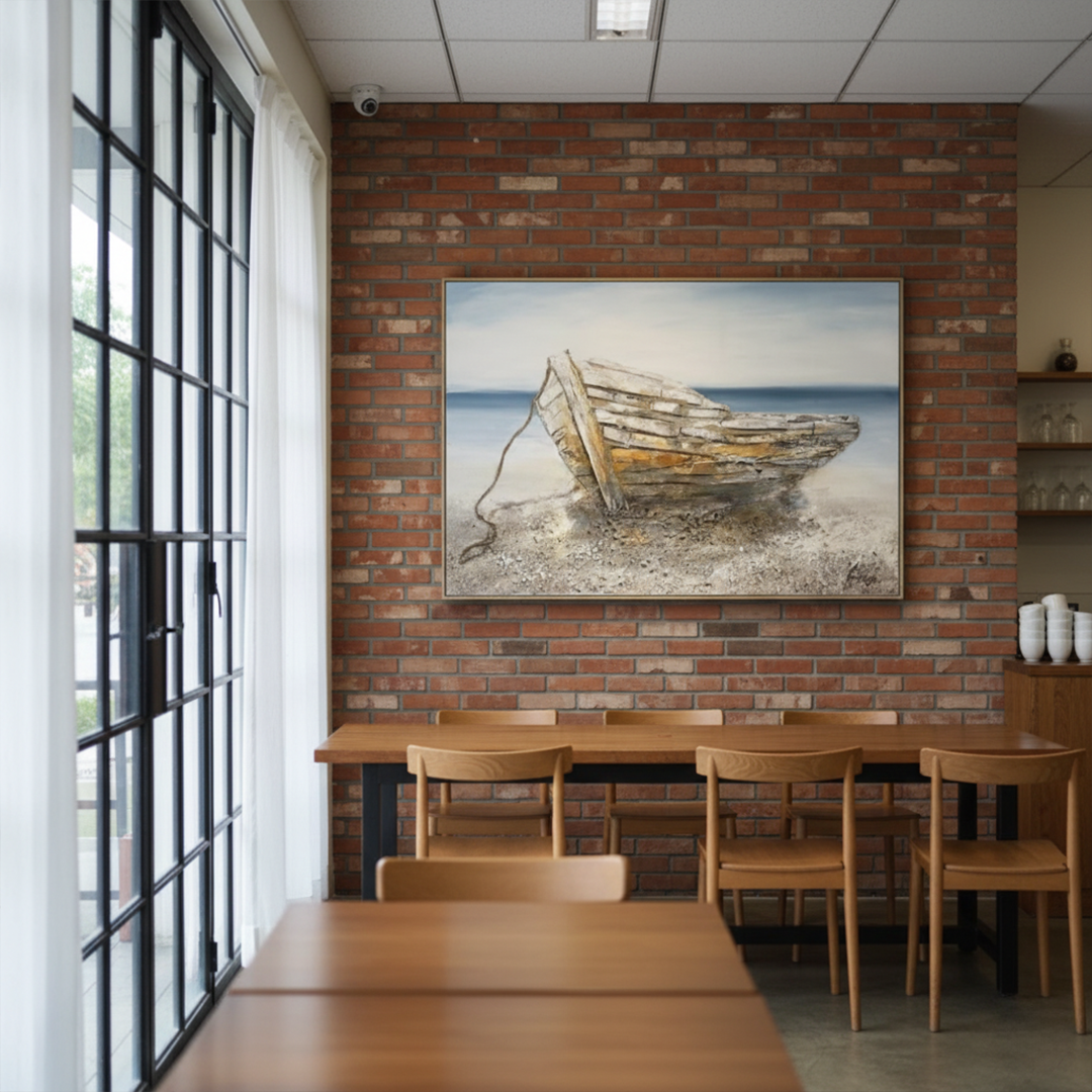 Dining area with wooden tables and chairs, and a painting of a boat on a brick wall.